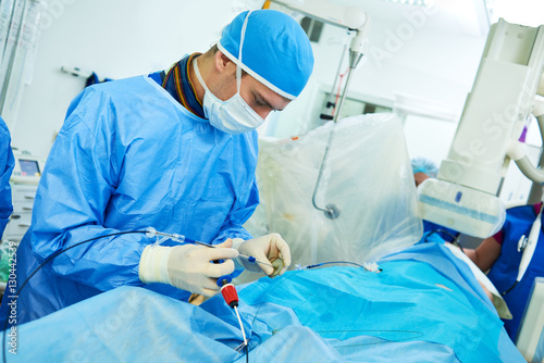 Interventional cardiology. Male surgeon doctor at operation photo