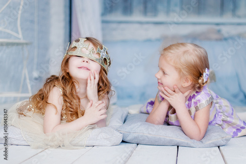 little girls play in their room with the crown