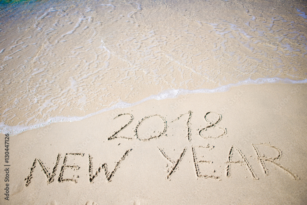 2018 New Year written in the white sand