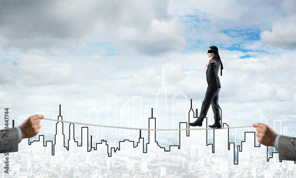 Business concept of risk support and assistance with man balancing on rope Business concept of risk support and assistance with man balancing on rope