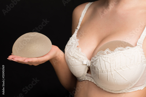 Obraz na płótnie Silicone implants on hand and natural brest