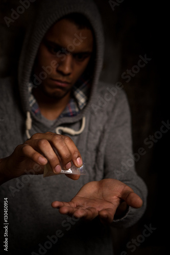 Drugs concept. Disease concept. Drug addict man taking drugs on street. Man using white powder and showing it to camera. © Svyatoslav Lypynskyy