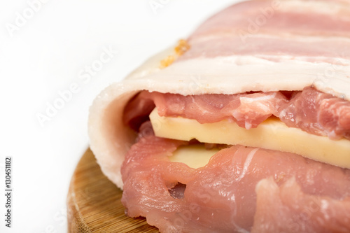 Closeup macro view of raw meat stuffed with yellow cheese and ro