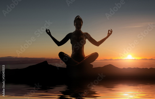 Silhouette of young meditating lady © konradbak