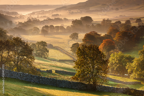 The Littondale Valley lit by the early morning light on a misty autumn morning in the Yorkshire Dales, Yorkshire