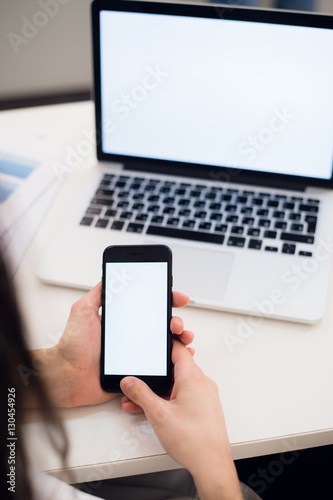 Close Up of woman hands using mobile phone and laptop computer with blank copy space screen for your advertising text message or content business.