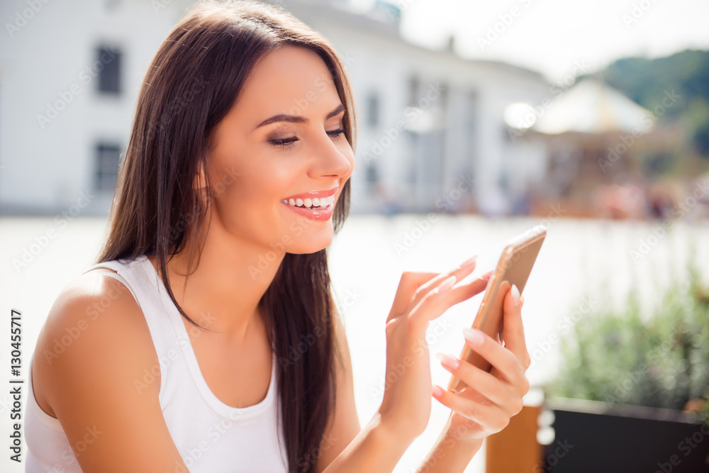 Attractive cheerful brunette woman having walk and typing sms Attractive cheerful brunette woman having walk and typing sms