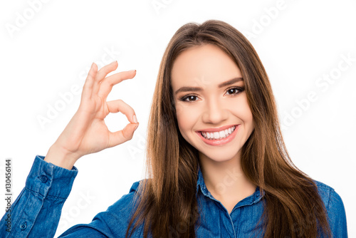 Portrait of cheerful happy brunette woman showing ok gesture