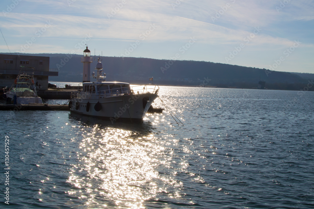 Sea dock, yacht in berth on sunset