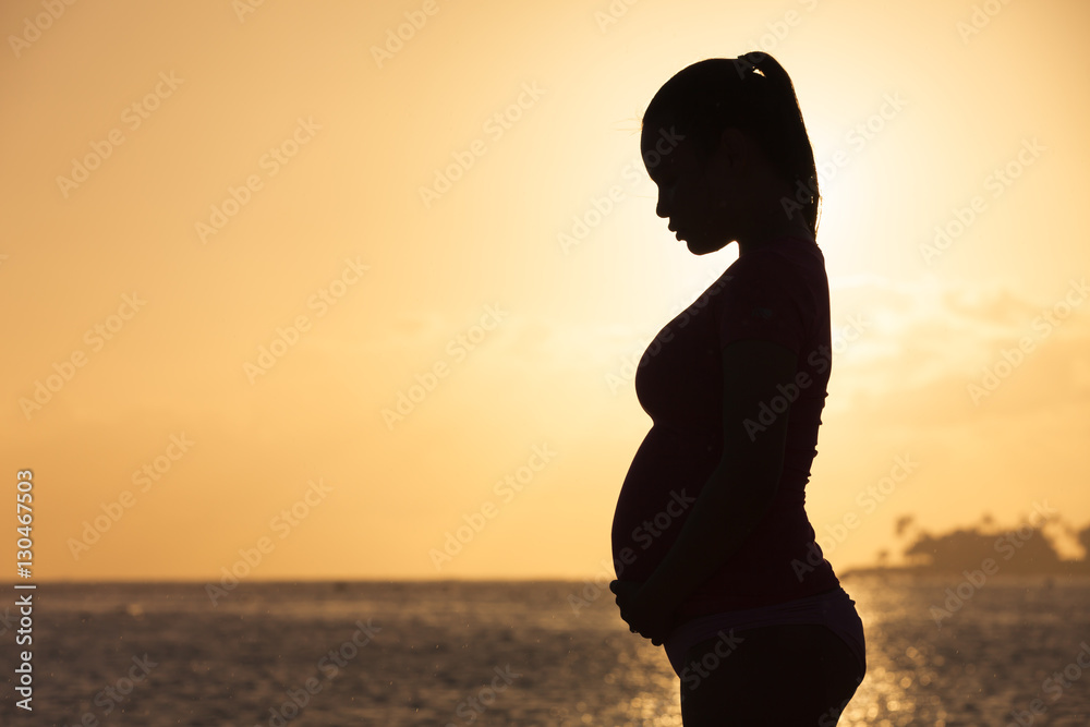 Silhouette of pregnant woman on the beach. 