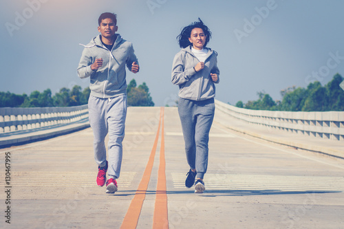 two young people running together on road. Man and woman jogging