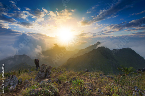 View from the highest mountain peak of Chiang Dao with beautiful cloudy sunset sky and a photographer standing shooting photo, Chiang mai, Thailand