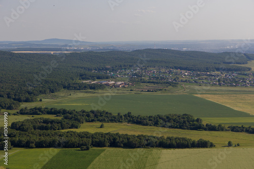 Landscape with village, houses, trees, fields. View from mountain Toratau