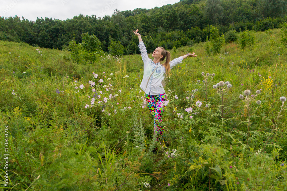 Young girl enjoying nature among the wildflowers in a forest Young girl enjoying nature among the wildflowers in a forest