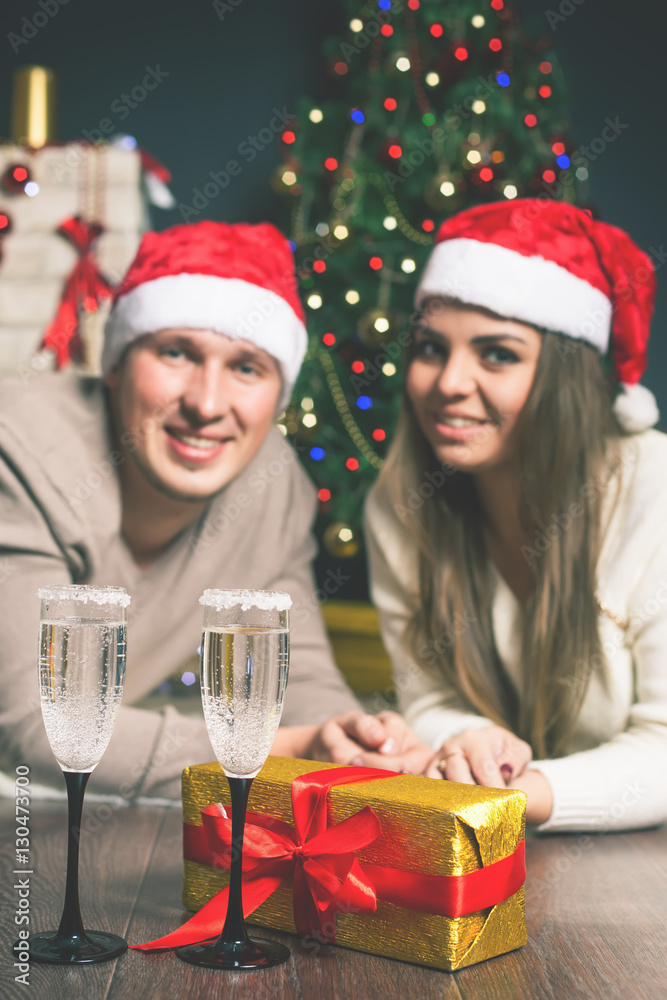 Couple young near decorated Christmas tree celebrating New Year Couple young near decorated Christmas tree celebrating New Year