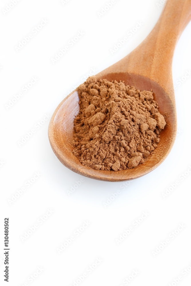 Carob Powder on Wooden Spoon on White Background Carob Powder on Wooden Spoon on White Background