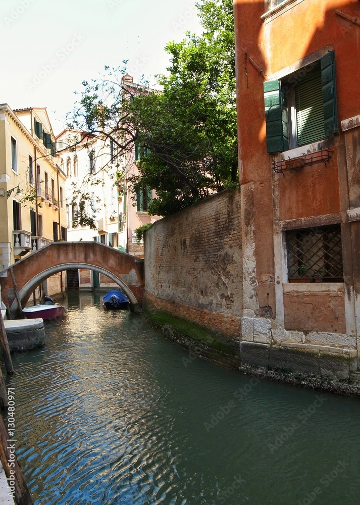 VENICE, ITALY - MAY 27, 2015 : street view of a boat on Venice's canal in the old city center of Venice.