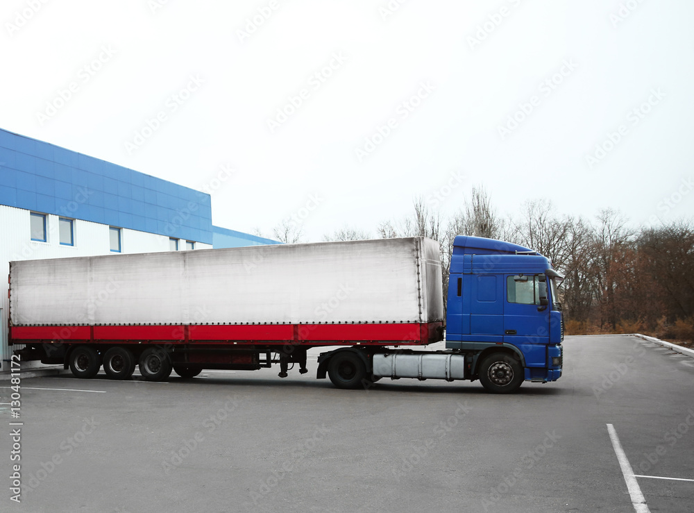 Truck on car parking near warehouse. Delivery and shipping concept. Truck on car parking near warehouse. Delivery and shipping concept.