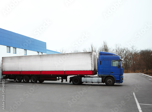 Truck on car parking near warehouse. Delivery and shipping concept.