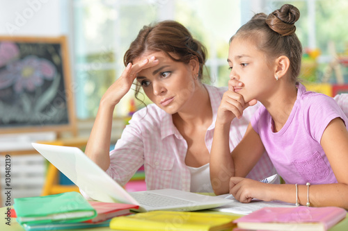 mother helping daughter with homework