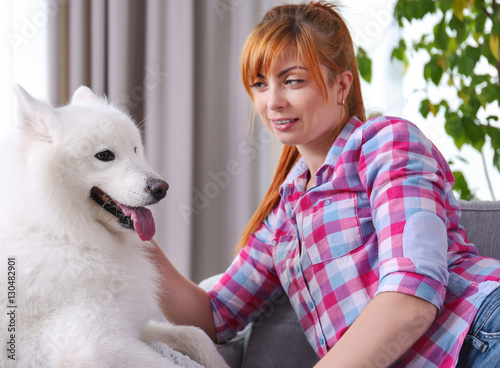 Girl with Samoyed dog on couch