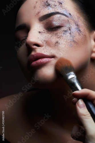 beauty and makeup.beautiful woman applying color powder on the face using makeup brush