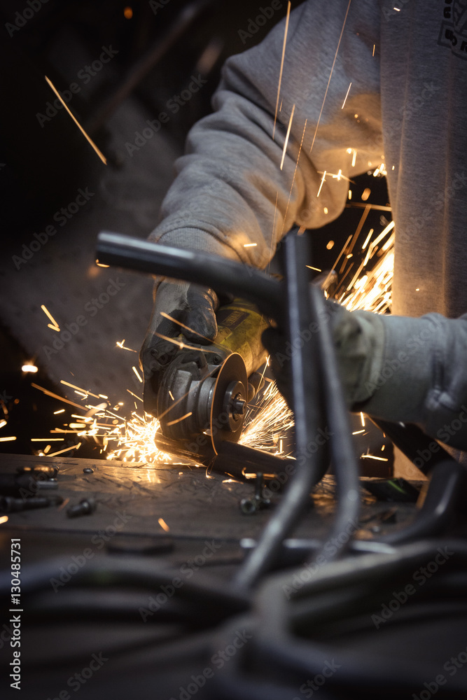 Grinding loops of steel pipe with many sparks on a work surface