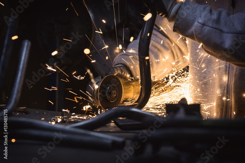 Obraz na płótnie Metal grinding on steel pipe with flash of sparks close up w salonie