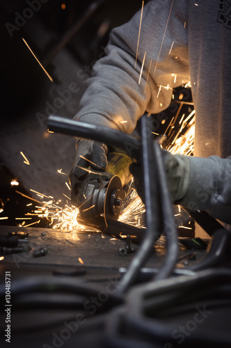 Obraz na płótnie Grinding loops of steel pipe with many sparks on a work surface w salonie