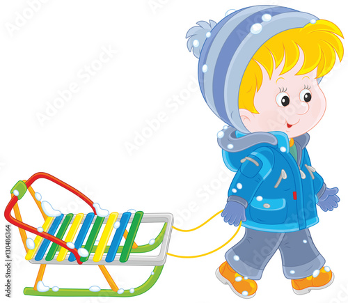 Little boy going with his sled