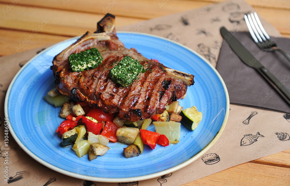 Grilled T-Bone Steak on serving board on wooden background Grilled T-Bone Steak on serving board on wooden background