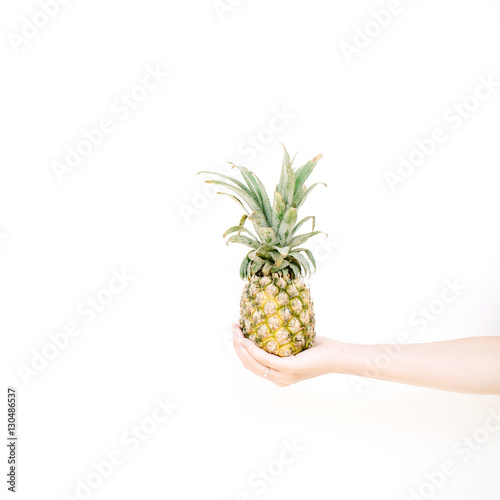 girl's hand holding pineapple. flat lat, top view