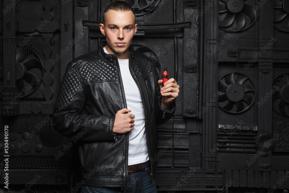 Φωτογραφία Fashionable and stylish man standing on black background with details and smoke