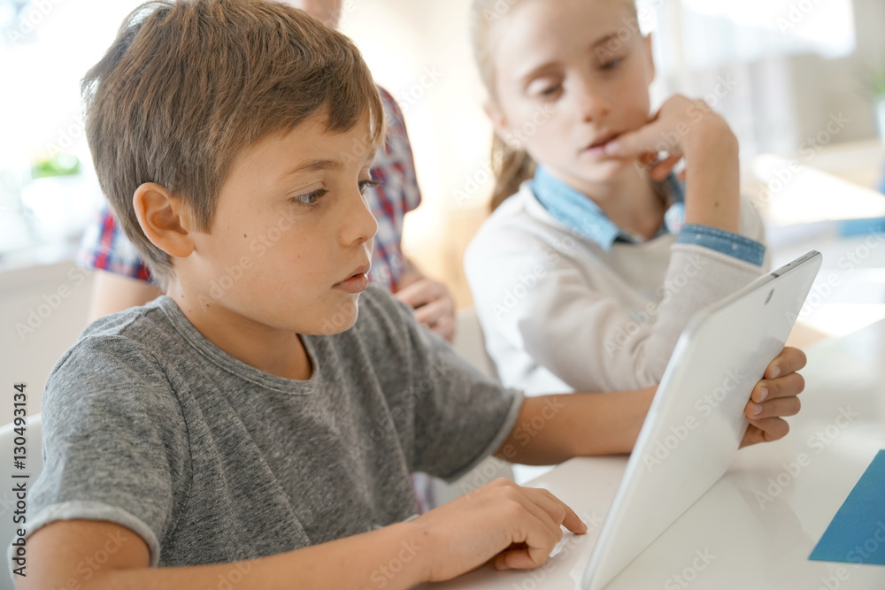 Kids in class working on digital tablet Kids in class working on digital tablet