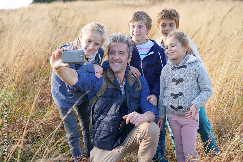 Man with kids in field taking selfie picture Man with kids in field taking selfie picture