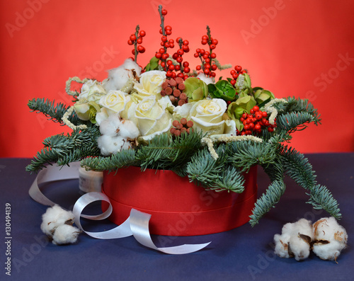 Christmas bouquet of roses and fir branches in a red box