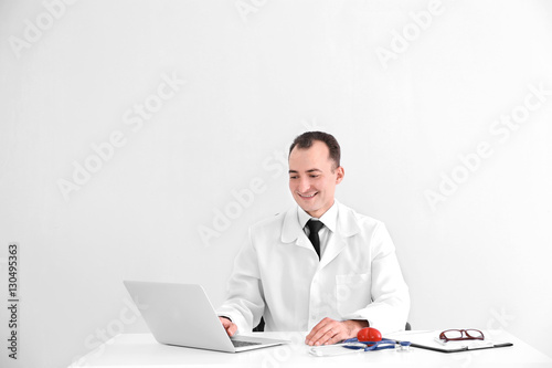 Doctor sitting at table wit...