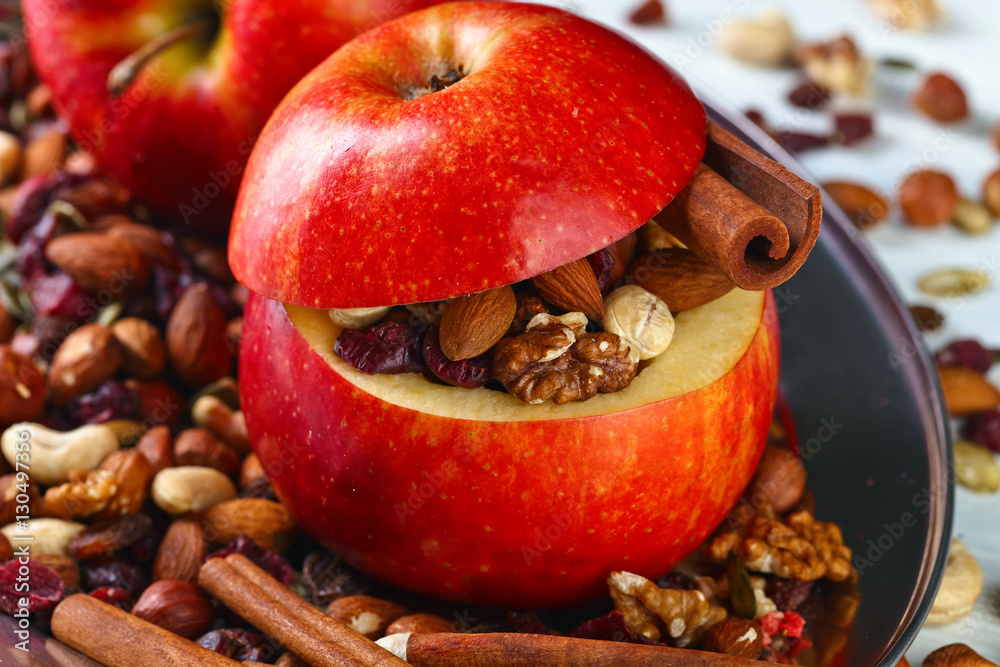 Red juicy apple with assorted nuts , raisins and cinnamon
