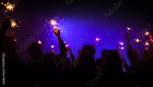Sparklers burn in hands, night party