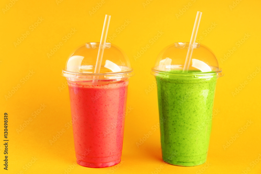 Delicious kiwi and strawberry milkshakes on yellow background Delicious kiwi and strawberry milkshakes on yellow background