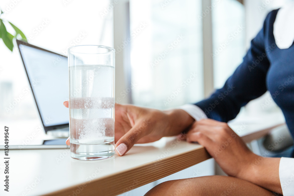 Cropped image of Business woman with water and pill Cropped image of Business woman with water and pill