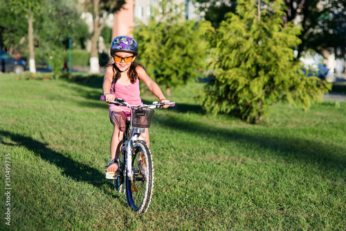 happy child girl riding bicycle in summer sunset
