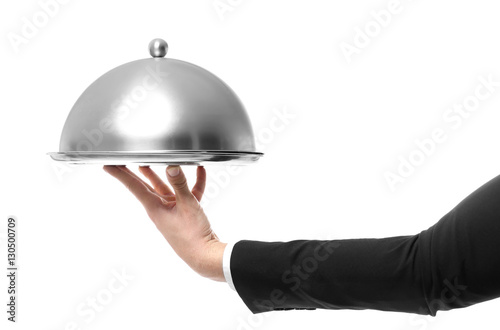 Hand of waiter holding metal tray with cover on white background photo