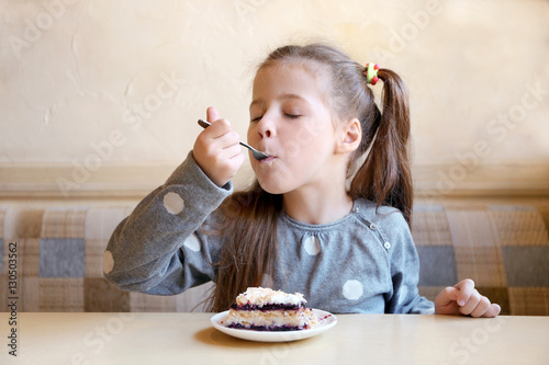 Cute little girl eating tas...