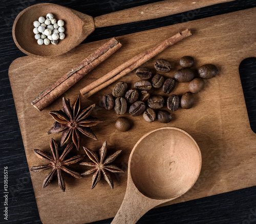 Fototapeta Naklejka Na Ścianę i Meble -  coffee, star anise, cinnamon, spoon on wooden cutting Board and dark background