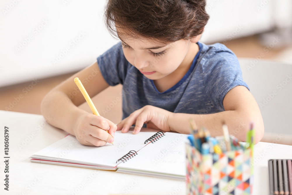 Cute little boy writing something in notebook Cute little boy writing something in notebook