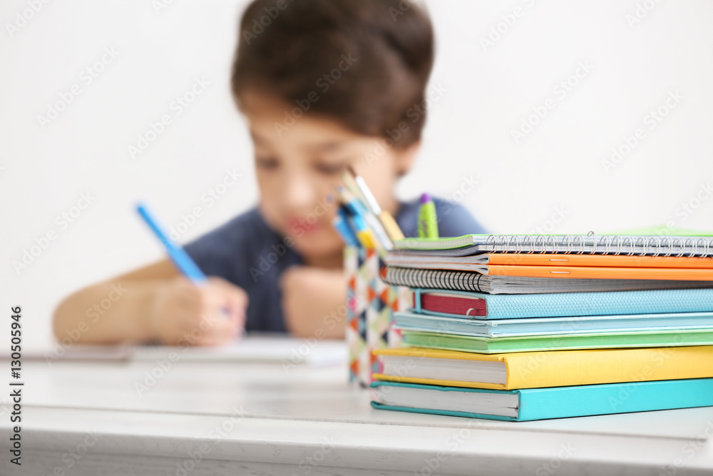 Color notebooks and books on blurred boy background, close up Color notebooks and books on blurred boy background, close up