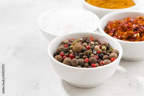 assortment of pepper, salt and spices in bowls, closeup