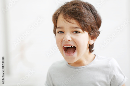 Cute emotional little boy on light blurred background