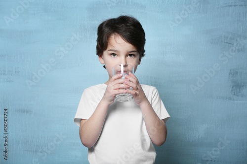 Cute little boy drinking wa...